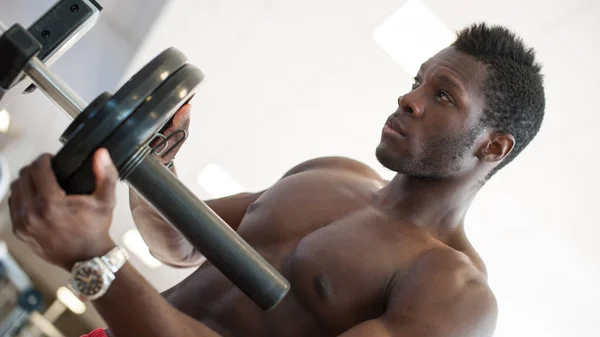 Sterke zwarte man aanpassen van zware lift op de bar in de sportschool. — Stockfoto