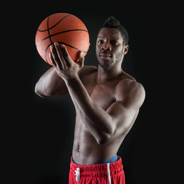 Confident young black man shirtless with basket ball against bla — Stock Photo, Image