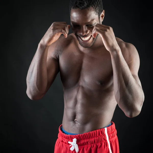 Сильный молодой черный мужчина без рубашки портрет против черного backgrou — стоковое фото