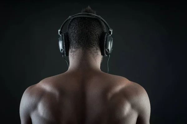 Black man with ear-phones detail against dark background. View f — Stock Photo, Image