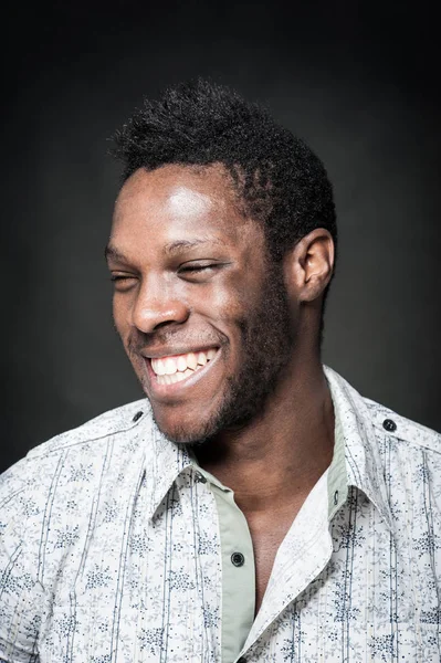 Glimlachende zwarte man close-up portret tegen donkere achtergrond. — Stockfoto