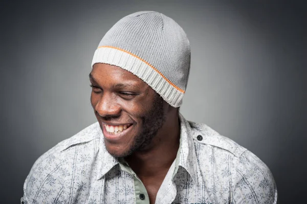 Glimlachende zwarte man close-up portret tegen grijze achtergrond. — Stockfoto