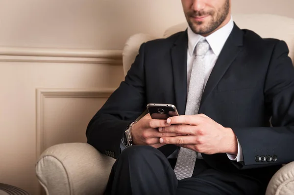 cropped shot of businessman sending message with mobile phone