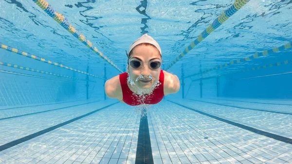 Professionele vrouw zwemmer binnen zwembad. — Stockfoto