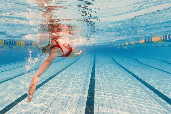 Professionele vrouw zwemmer binnen zwembad. — Stockfoto