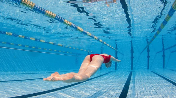 Professionele vrouw zwemmer duiken binnen zwembad. — Stockfoto