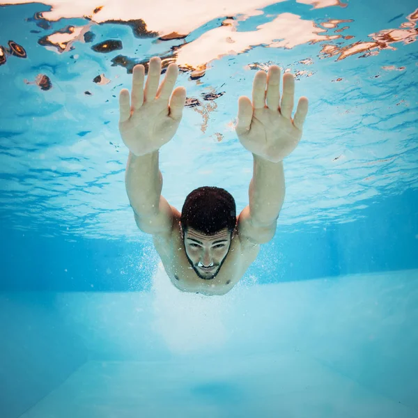 Onderwater man binnen zwembad na het dompelen. — Stockfoto