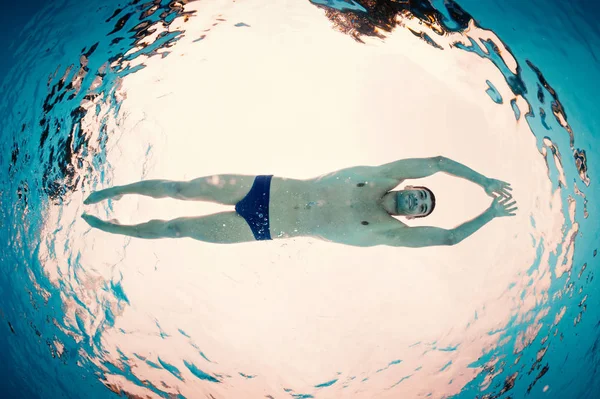 Underwater man inside swimming pool from below. Full body. — Stock Photo, Image