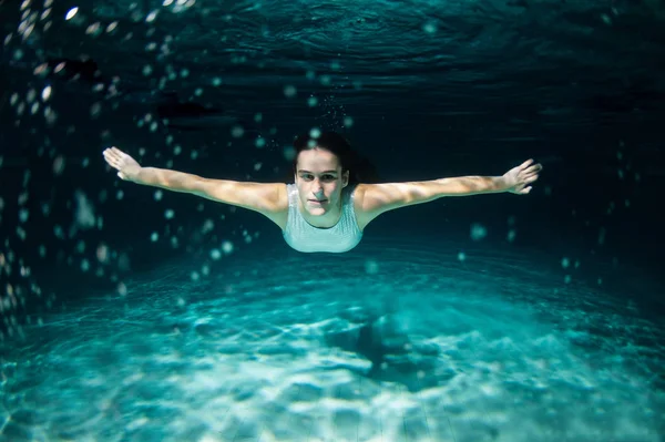 Retrato de mujer bajo el agua en la piscina por la noche. Soñando. — Foto de Stock