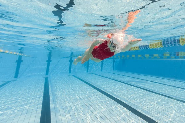 Vrouw professionele zwemmer draagt rode zwembroek binnen zwemmen — Stockfoto