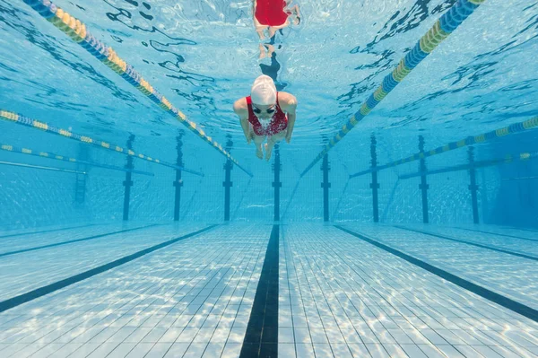 Vrouw professionele zwemmer draagt rode zwembroek binnen zwemmen — Stockfoto