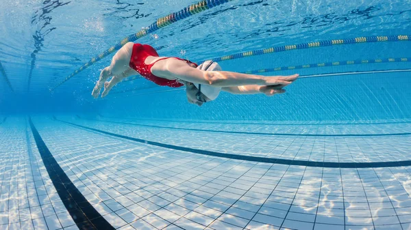 Vrouw professionele zwemmer draagt rode zwembroek binnen zwemmen — Stockfoto
