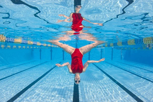 Professionele vrouw die synchroon zwemmen ondersteboven oefent — Stockfoto