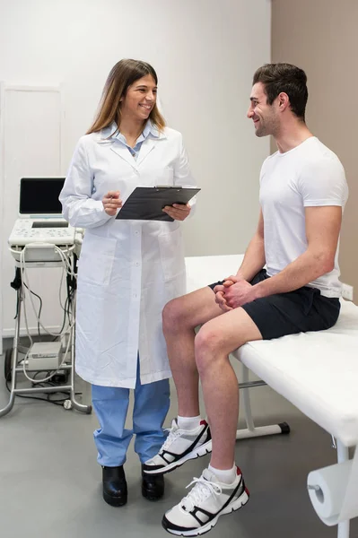 Médecin rendant visite à son patient masculin et prenant des notes au bureau . — Photo