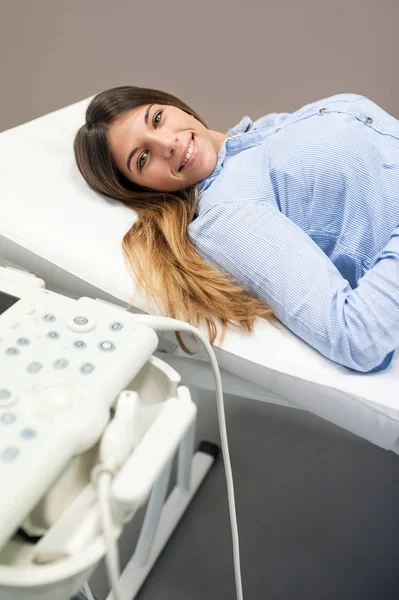 Patientin legt neben Ultraschallgerät in Arztpraxis — Stockfoto