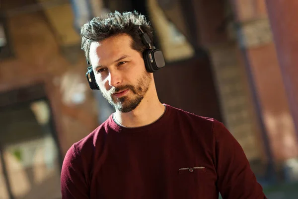 Young man with headphones close up portrait outdoor in the city