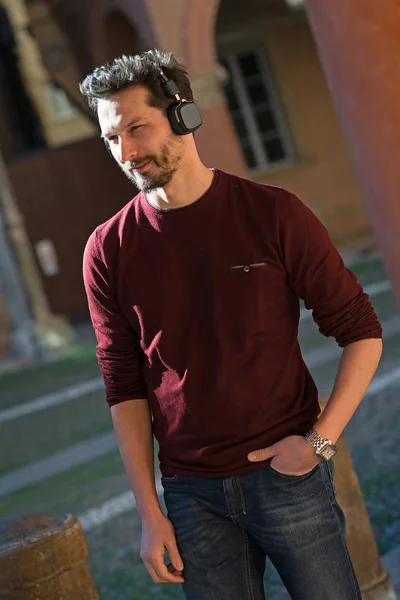 Jeune homme avec écouteurs gros plan portrait en plein air dans la ville — Photo