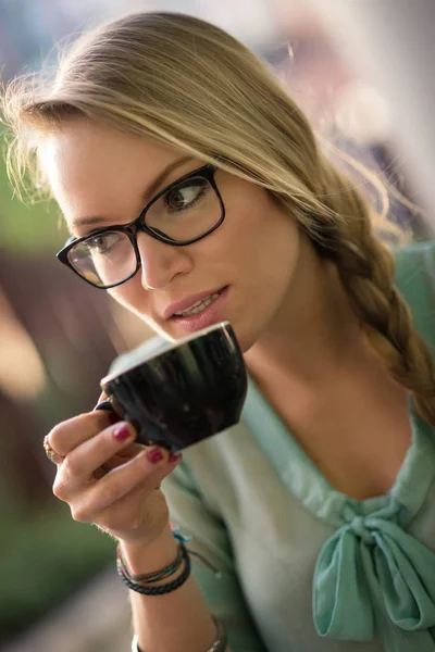 屋外のカフェでコーヒーを飲む若いブロンドの女性 被写界深度の浅い — ストック写真