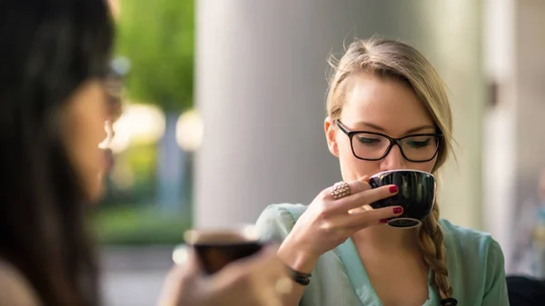屋外のカフェで友人とコーヒーを飲む若いブロンドの女性 被写界深度の浅い — ストック写真