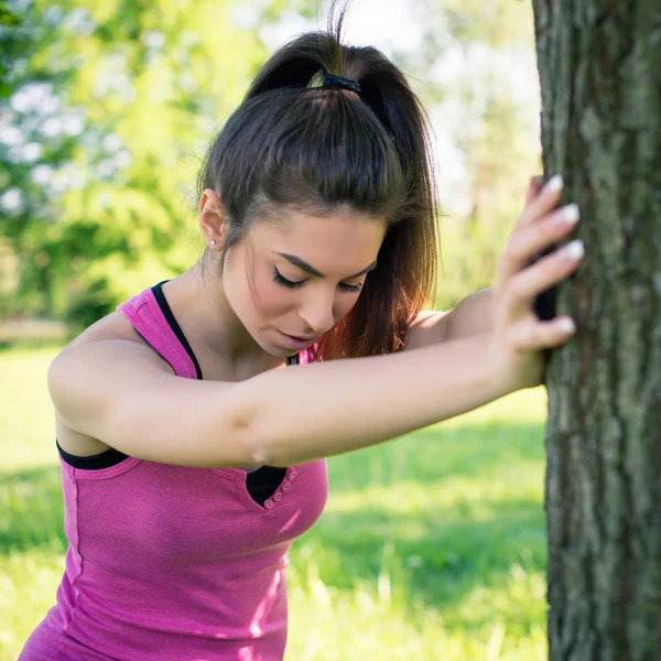 Portret Młodej Kobiety Rozciągający Nogi Drzewo Zewnątrz Parku — Zdjęcie stockowe