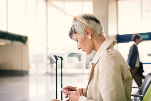 シャルル ゴール空港で携帯電話でメッセージを送信するビジネスウーマン — ストック写真