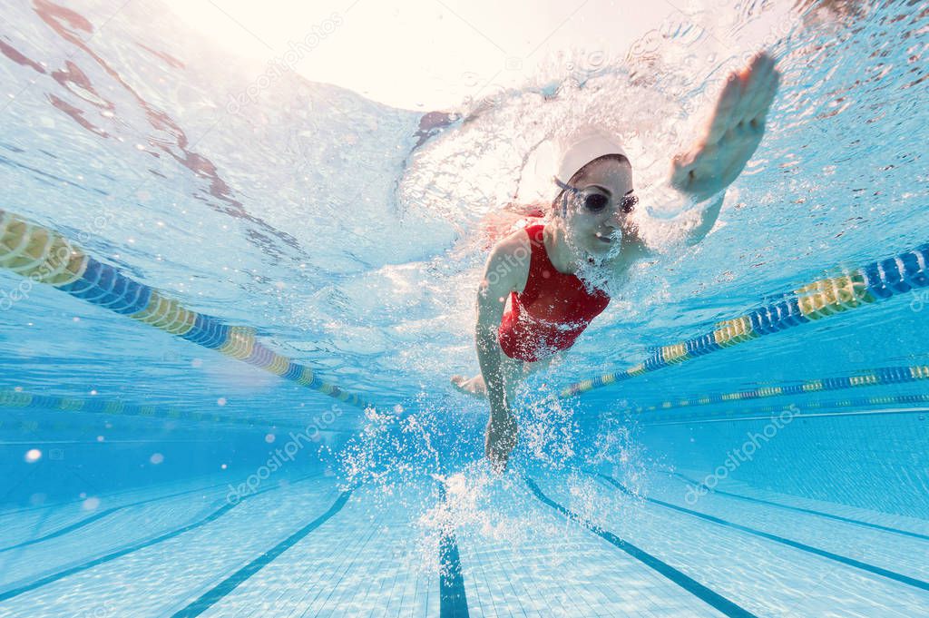 Professional woman swimmer inside swimming pool.