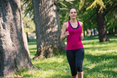 Genç ve güzel bir kadın parkta koşuyor..