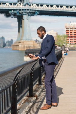 Genç işadamı cep telefonuyla mesaj gönderiyor.