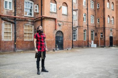 Shoreditch ilçesinde duran genç dövmeli adamın tam vücut portresi. Londra, İngiltere. Hipster tarzı.