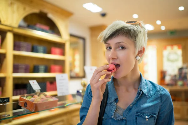 Young Blonde Woman Portrait Eating French Pastry Macaron Typical Shop — Stock Photo, Image