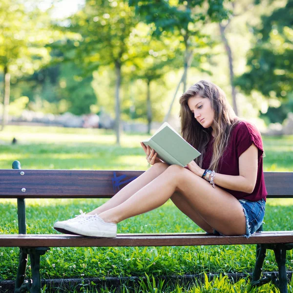 Młoda Kobieta Czytając Książkę Pod Drzewem Parku Obraz Filtrowany — Zdjęcie stockowe