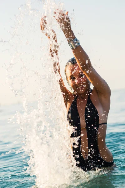 Aktivní Mladá Blondýnka Stříkající Vodu Pláži — Stock fotografie