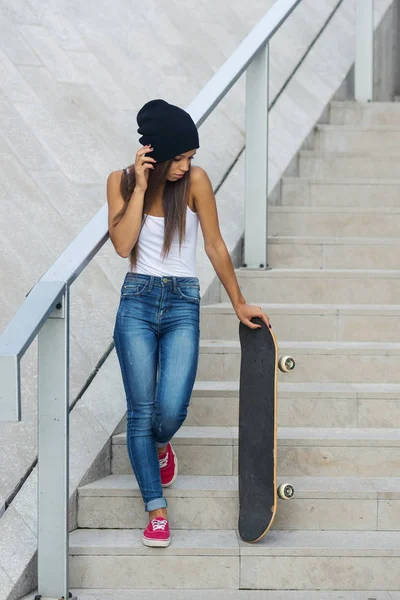 階段上のスケートボードのフルボディの肖像画を持つティーンエイジャー. — ストック写真