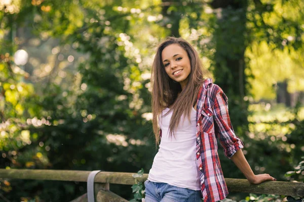 Hübsche Teenager-Porträt mit natürlichen grünen Heckenhintergrund in — Stockfoto