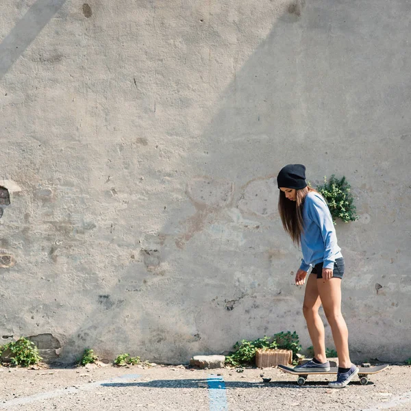 Adolescent portrait équitation skateboard contre béton mur . — Photo