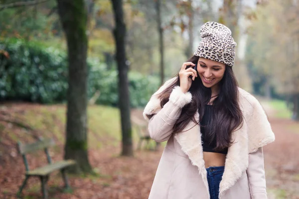 公園で屋外で電話で話す幸せな若い女性 — ストック写真