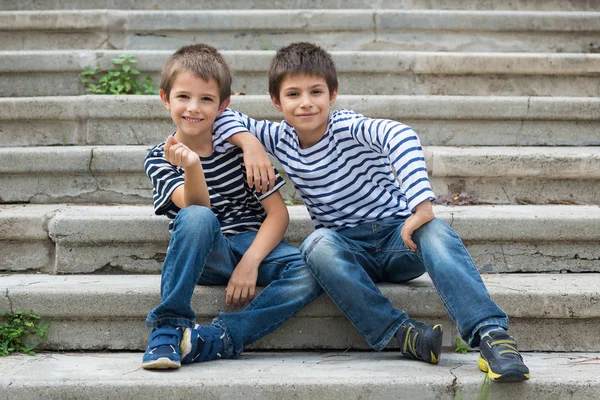 Two brothers portrait having fun sit on stairs outdoors. — Stock Photo, Image