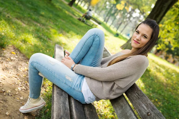 公園でリラックス自然な緑の背景を持つ美しい若い女性の肖像画 — ストック写真