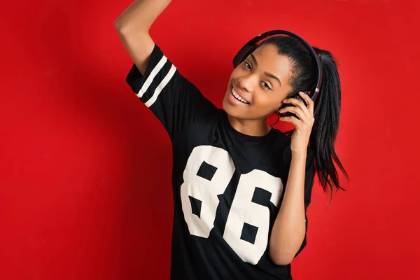 Hermoso Adolescente Brasileño Sonriente Con Auriculares Contra Fondo Rojo — Foto de Stock