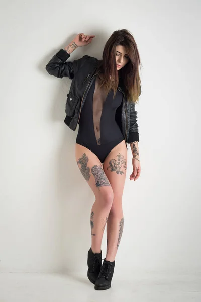 Femme sensuelle avec tatouage veste en cuir contre blanc w — Photo