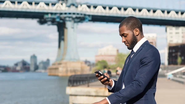 Jonge zakenman stuurt sms-bericht met mobiele telefoon w — Stockfoto
