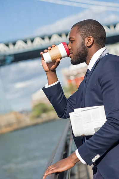 Young businessman portrait drinking a coffee and reading newspap — Stock Photo, Image