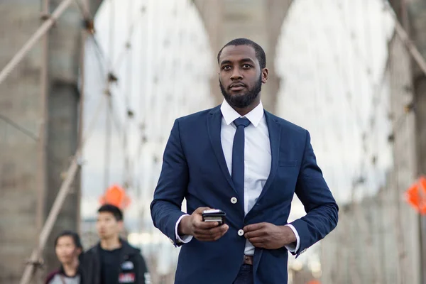 Junger Geschäftsmann mit Handy auf der Brücke von Brooklyn. neues Jahr — Stockfoto
