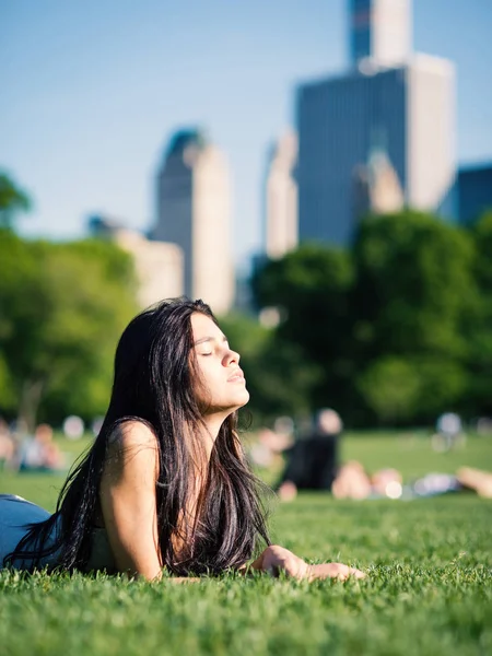 セントラルパークでリラックスした官能的な若い女性が芝生の上に横たわっています ニューヨーク フィルタリングされた画像 — ストック写真