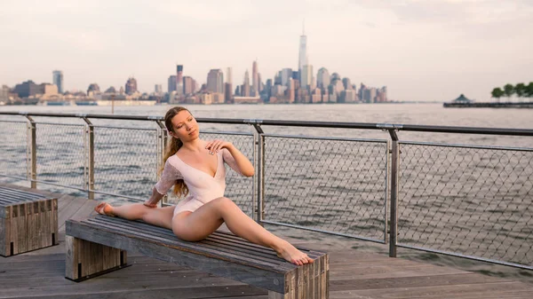 Young beautiful ballerina dancing along New Jersey waterfront with New York skyline in the background. Ballerina Project.
