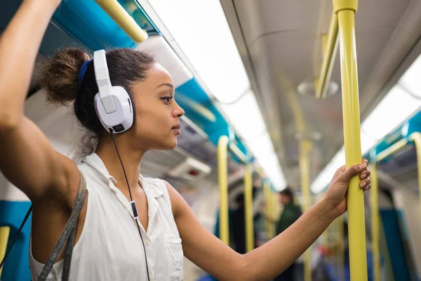 Ritratto di giovane donna all'interno della metropolitana di Londra ascoltando m — Foto Stock