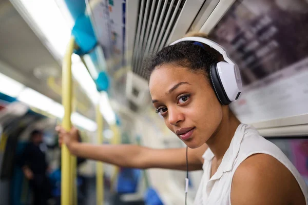 Intenso ritratto di giovane donna all'interno della metropolitana di Londra ascoltare — Foto Stock