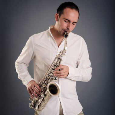 Saksafoncu adam karanlık arka plan karşı izole. Stüdyo portresini kapat.