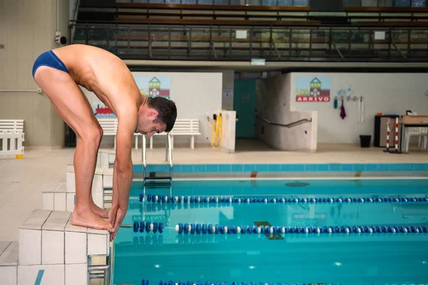 Yüzme havuzu içinde profesyonel adam yüzücü atlamak için hazırlanıyor. — Stok fotoğraf