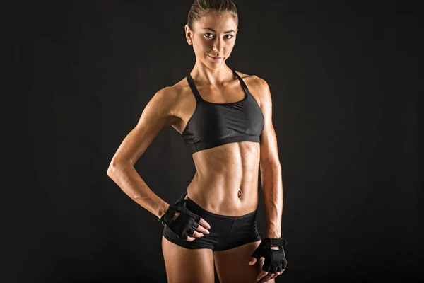 Confiante jovem esportivo mulher retrato contra fundo preto . — Fotografia de Stock